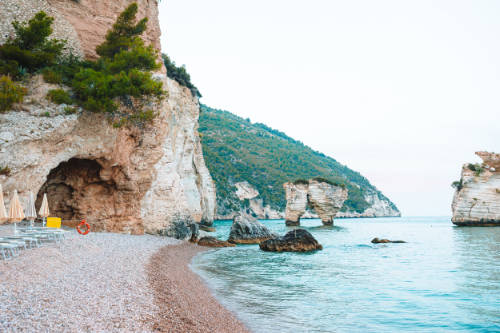 Picturesque islets Faraglioni di Puglia in bay Baia Delle Zagare. Mattinata Faraglioni stacks and beach coast of Mergoli, Vieste Gargano, Apulia, Italy.