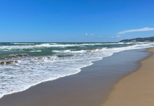 Vista de la playa de Castelldefels, con la arena y el mar en primer plano.